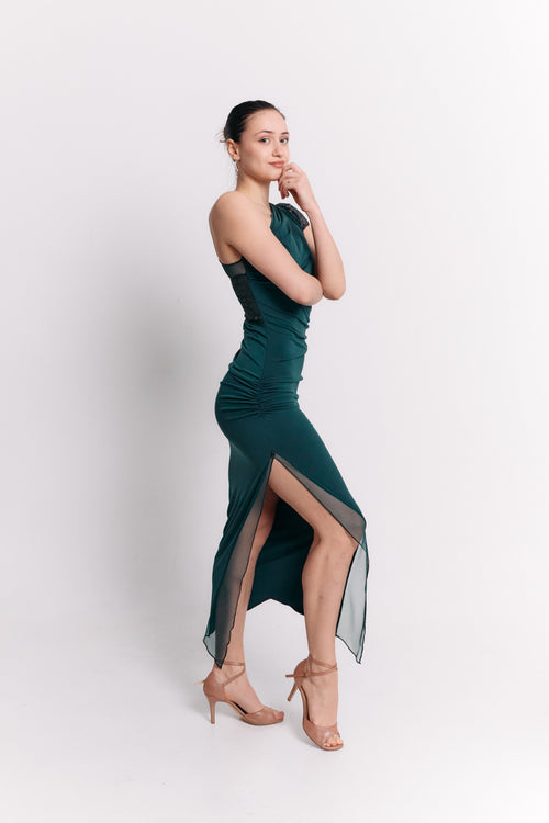Woman wearing a green dress with a slit on a white background