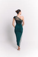 Woman wearing a one-shoulder green dress with sheer panels on a white background