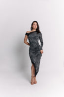 Woman wearing a black and white leopard patterned off-shoulder dress on a light gray background