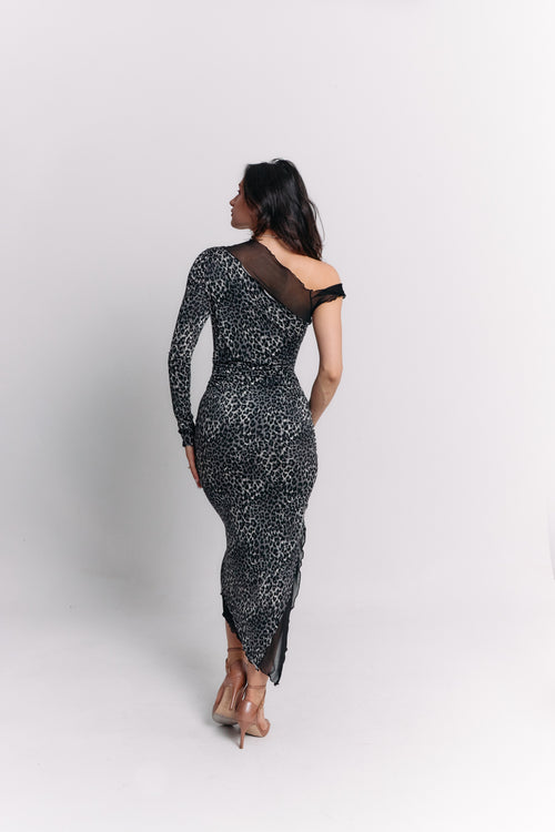 Woman wearing a black and white leopard patterned dress on a white background