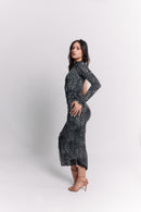 Woman wearing a black and white leopard patterned dress on a white background