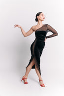 Woman wearing a black velvet dress with sheer sleeve on a white background