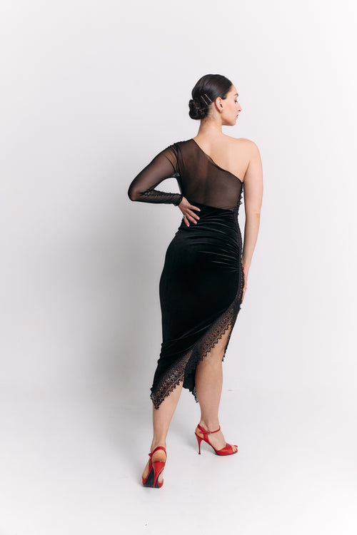 Woman wearing a black one-shoulder dress with lace details on a white background