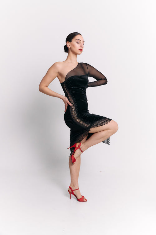 Woman wearing a black dress with sheer sleeve and red shoes on a white background