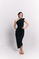 Woman wearing a black one-shoulder dress on a white background