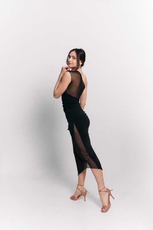 Woman wearing a black dress with sheer panels on a white background