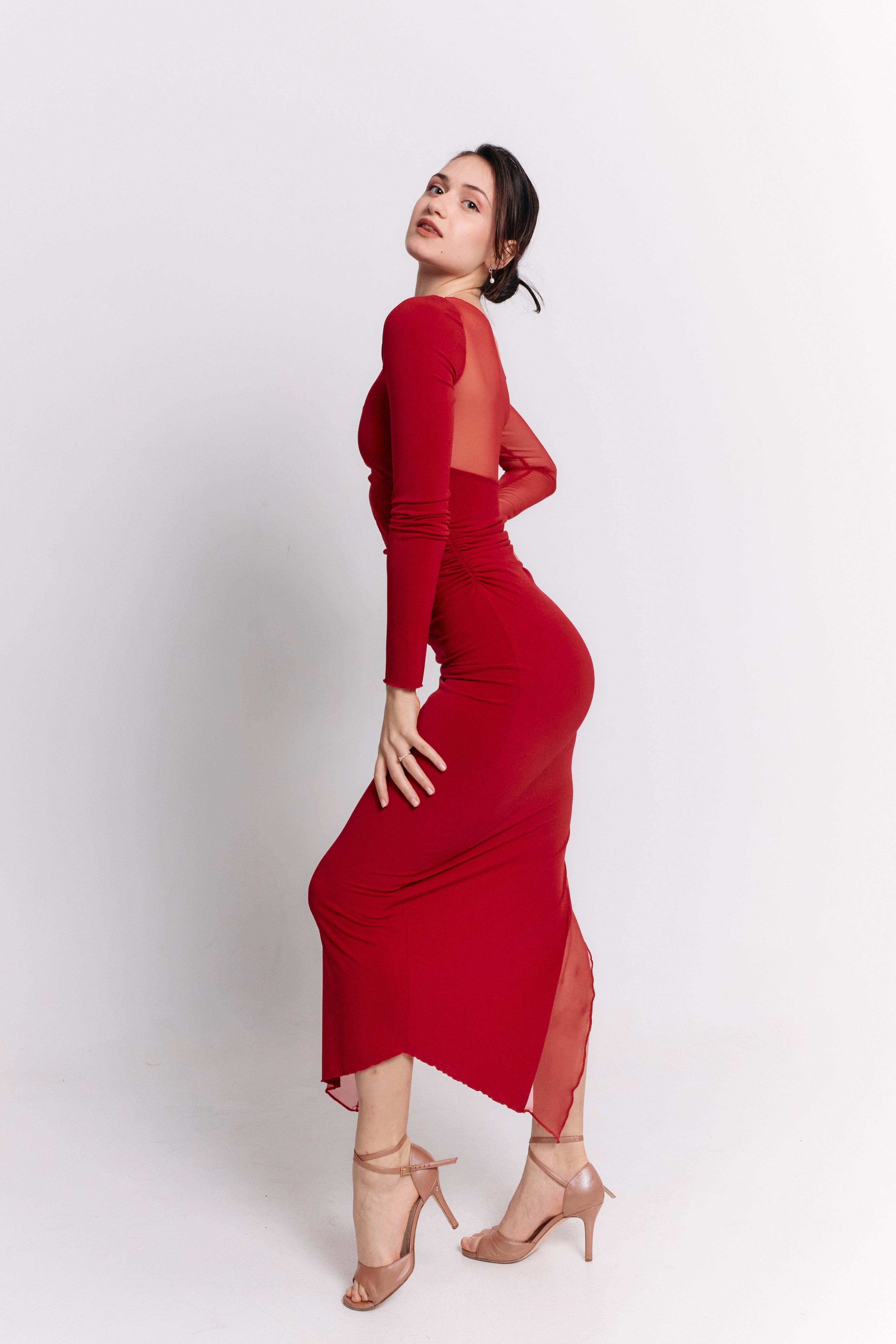 Woman wearing a red dress with cut-out sleeves on a white background