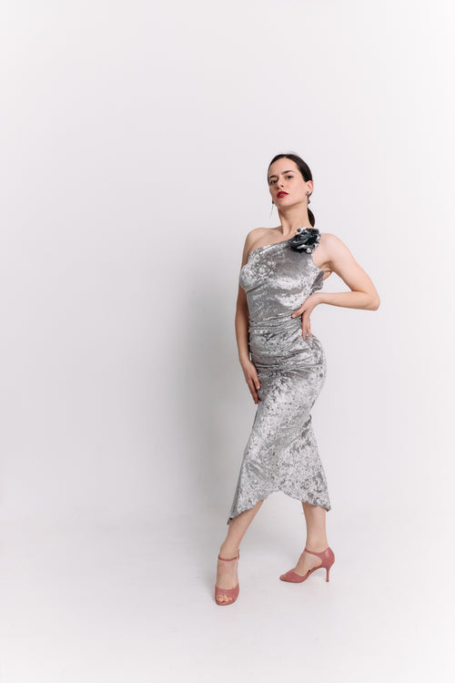 Woman wearing a silver dress with a flower detail on a white background