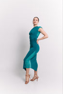 Woman wearing a turquoise dress with lace details on a white background