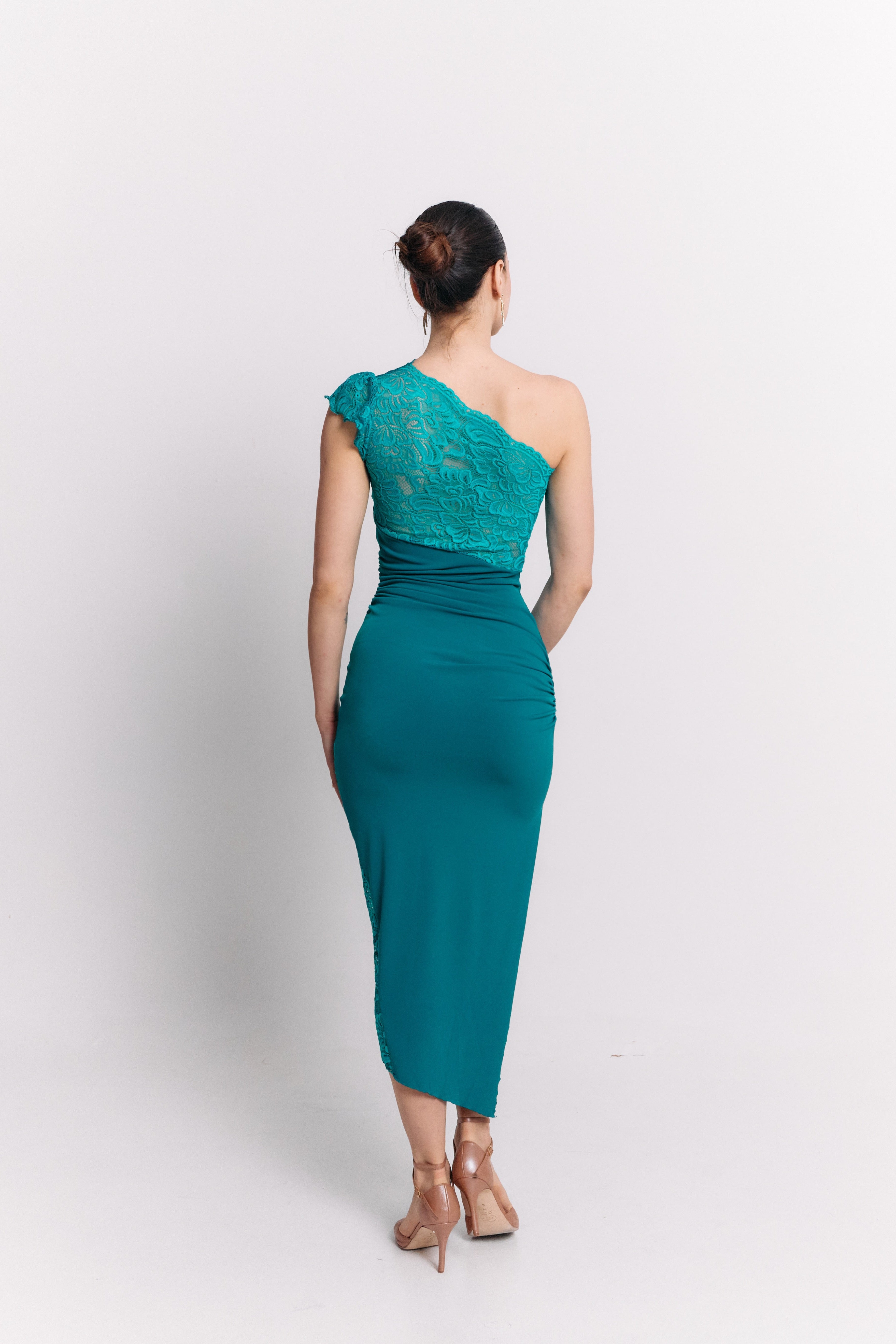 Woman wearing a turquoise one-shoulder dress on a white background