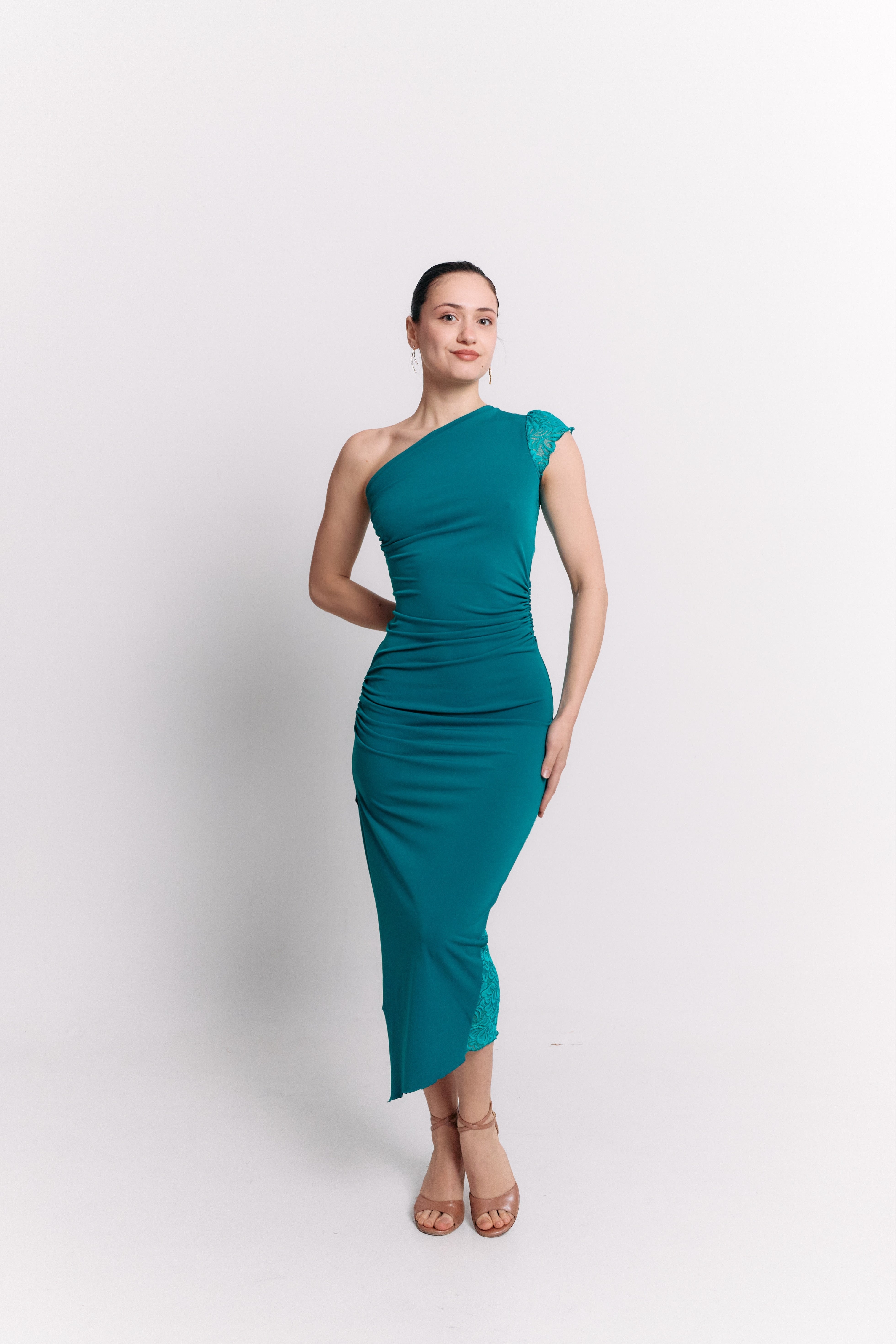 Woman wearing a turquoise one-shoulder dress on a white background